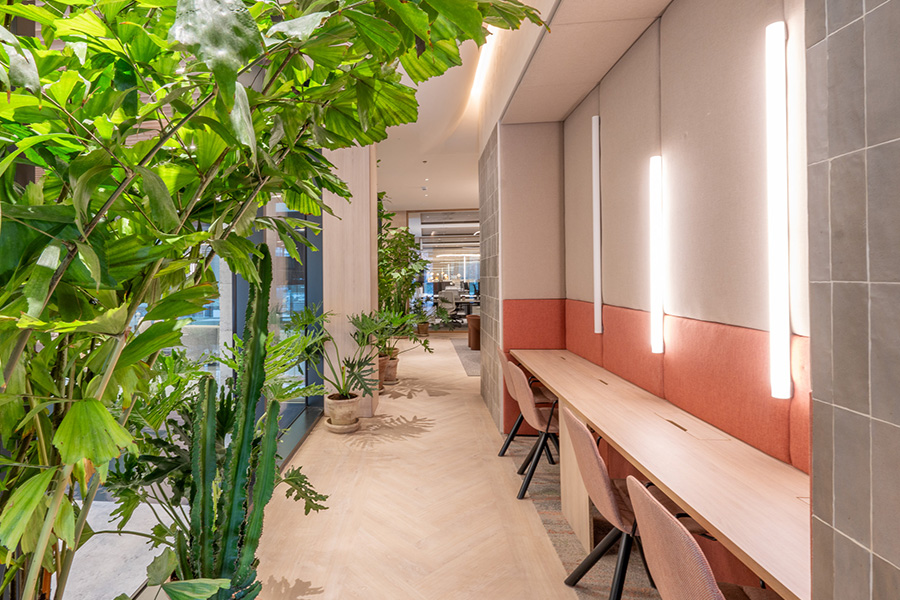 Espacio de coworking abierto con escritorios y sillas blancas.