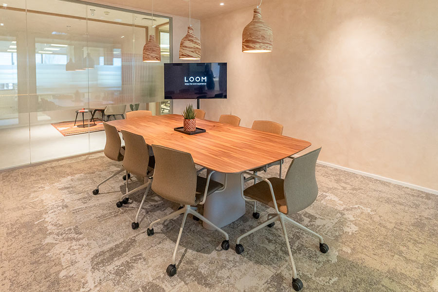 Espacio de coworking abierto con escritorios y sillas blancas.